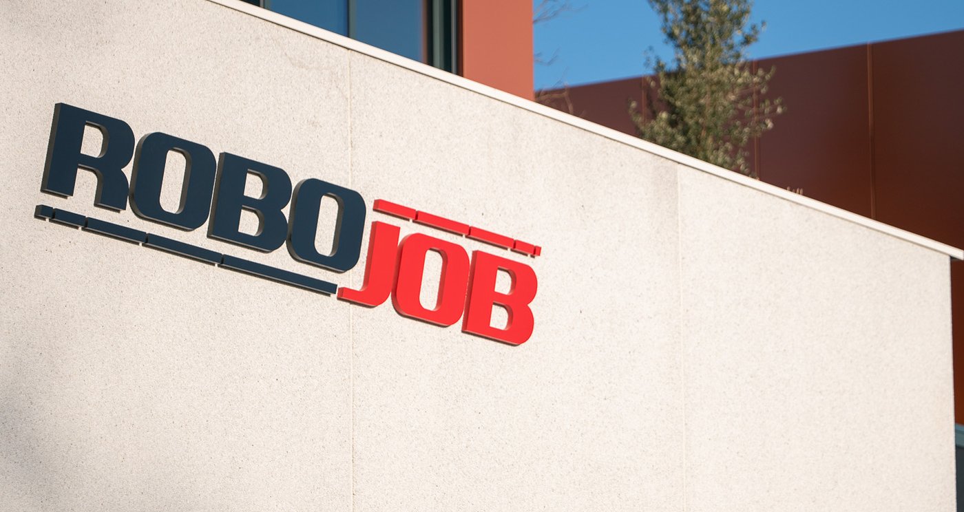 robojob headquarters with the big logo on the facade and a few trees